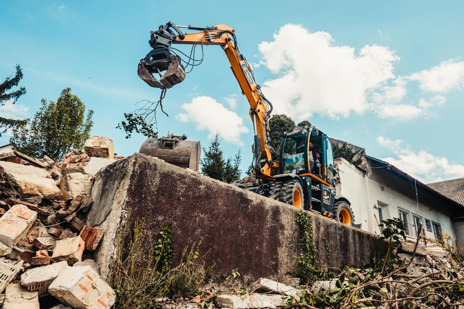 A bulldozer efficiently demolishing an old building, clearing rubble.